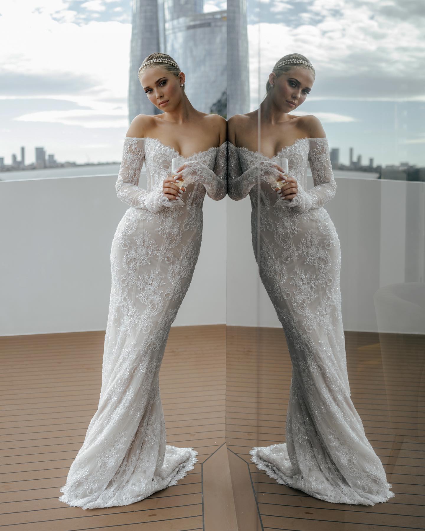 Bridal dress featuring long sheer lace sleeves and stunning open-back illusion detail.