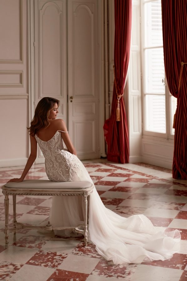 Elegant backless bridal gown with sculpted fit-and-flare silhouette and minimalist spaghetti straps.