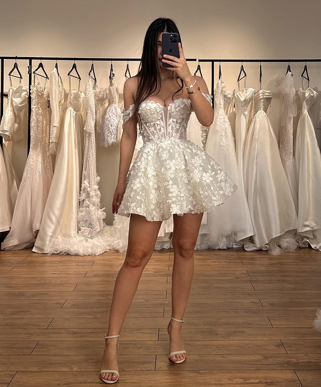 Mini bridal gown featuring soft off-shoulder sleeves and delicate lace appliques on tulle, ideal for a romantic boho beach wedding ceremony.