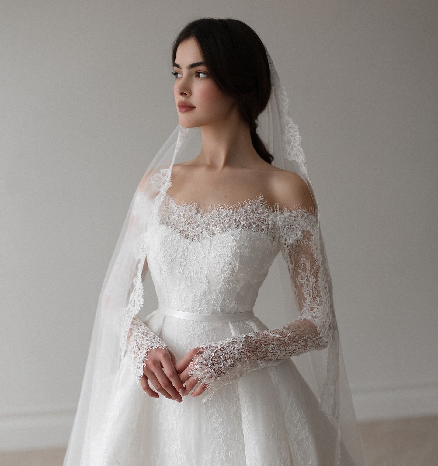 Off-the-shoulder wedding dress with lace overlay and princess silhouette