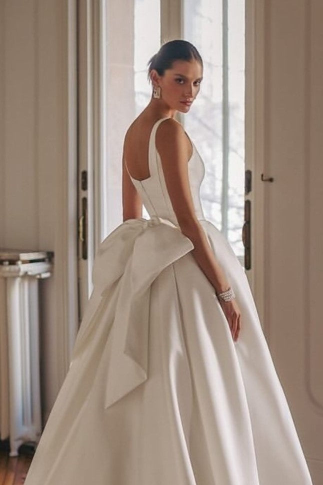 Back view of a-line wedding dress with oversized satin bow and flowing train