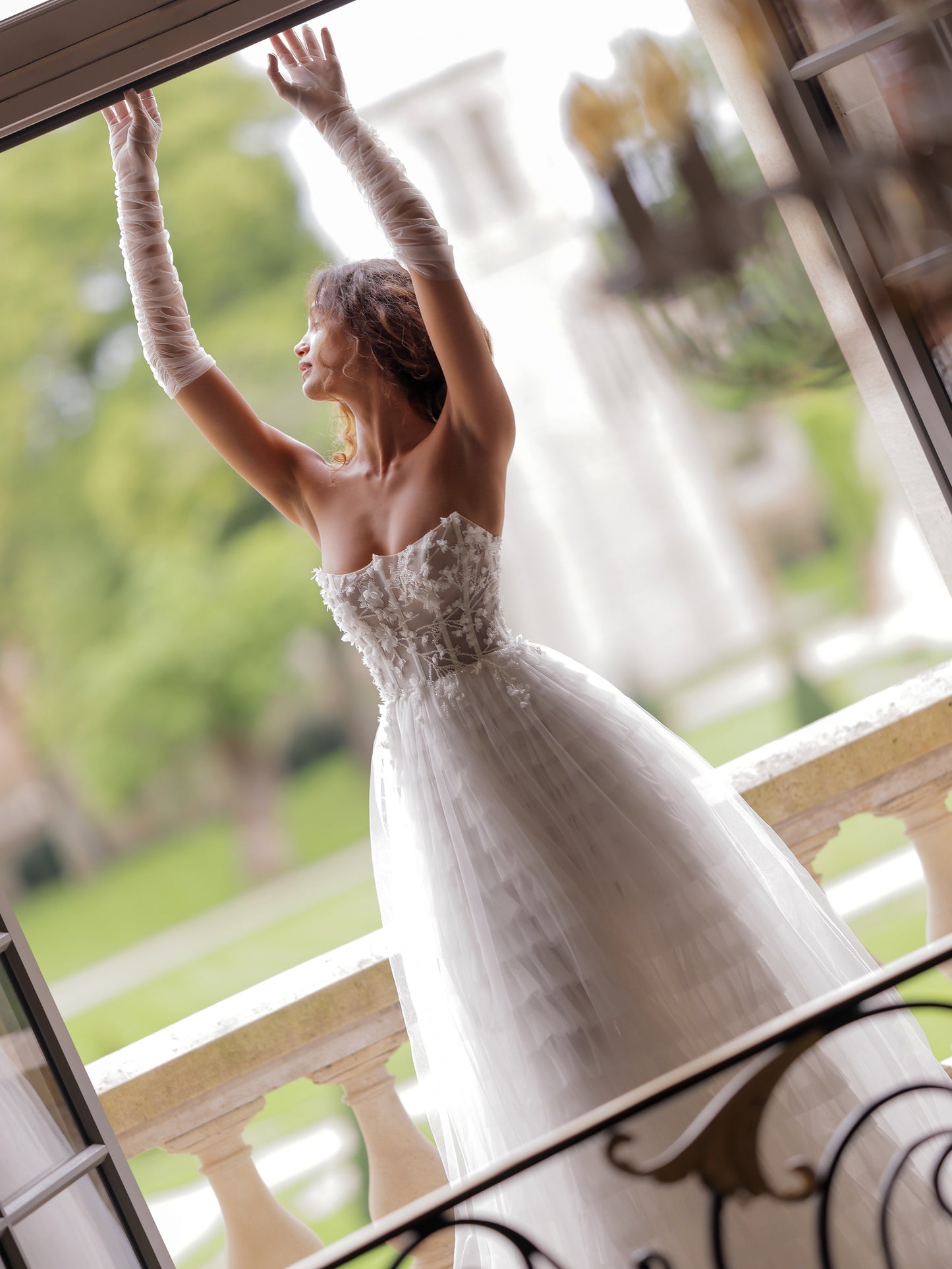 Bride wearing sheer gloves with boho corset tulle dress
