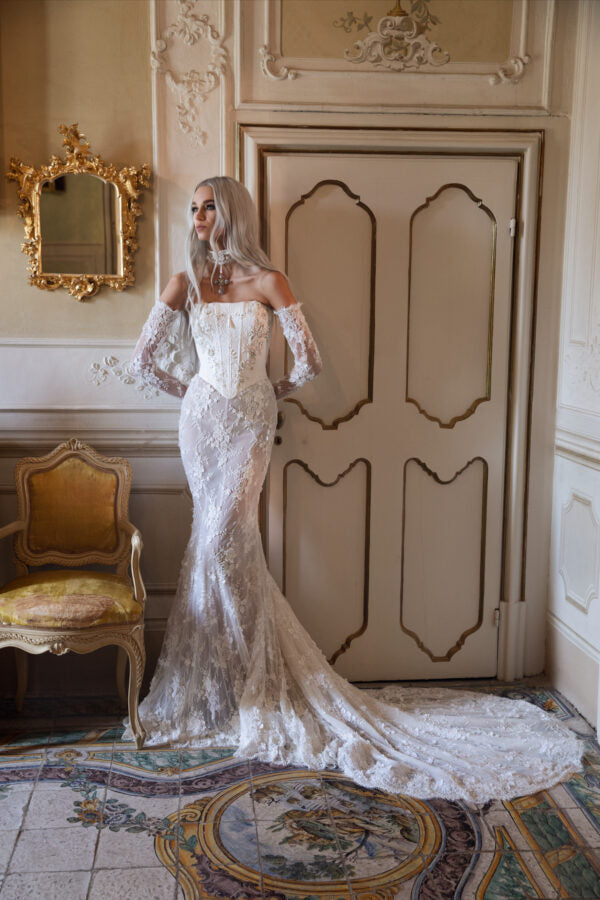 Elegant back view of corset bridal gown with sculpted lace and dramatic chapel train.