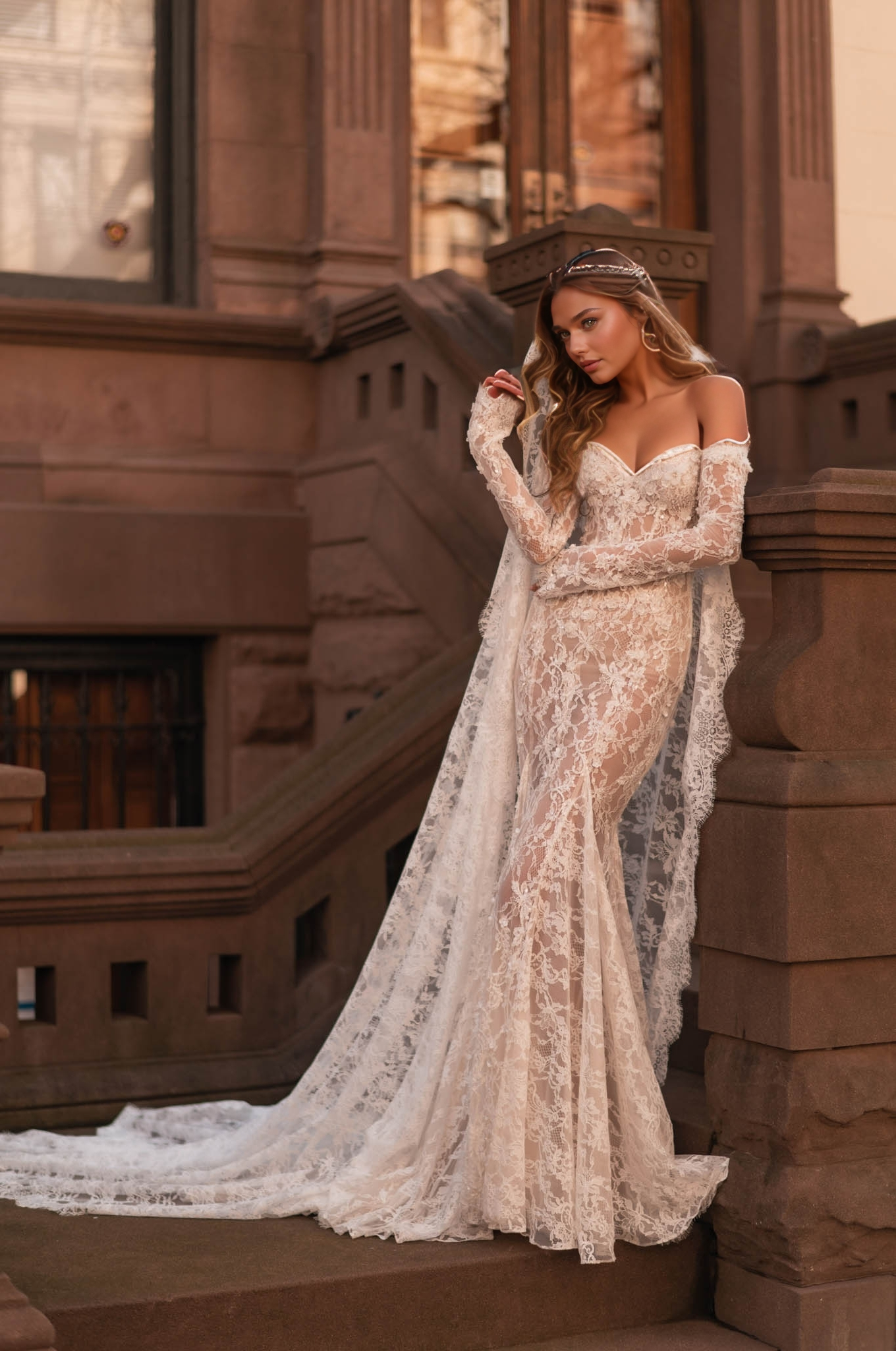 elegant long-sleeve lace wedding dress with off-shoulder design, sheer illusion, and cape in a classic setting