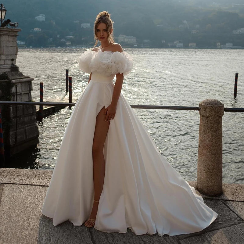 Off-shoulder ball gown wedding dress with 3D floral puff sleeves and high slit, perfect for romantic brides seeking elegance and uniqueness.