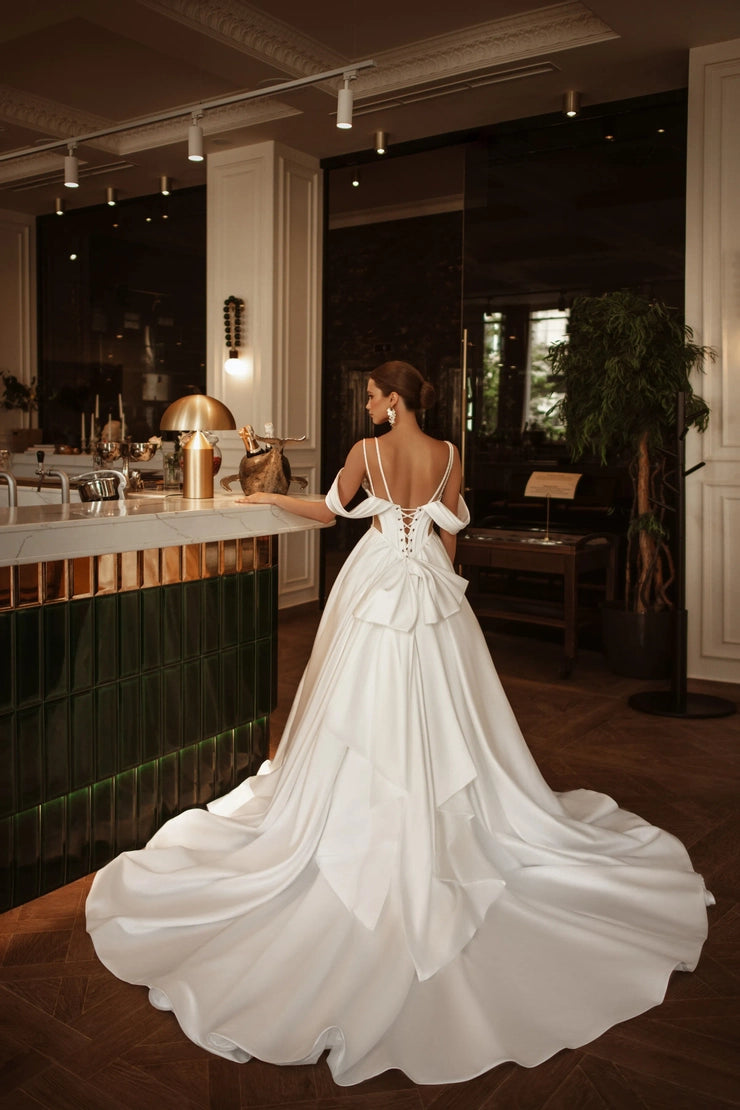 Off-shoulder sweetheart wedding dress styled with crystal corset and modern silhouette.