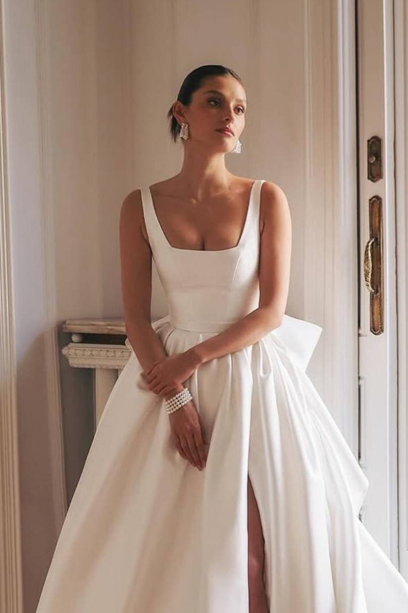 Structured satin bridal gown featuring high side slit and clean lines for modern brides