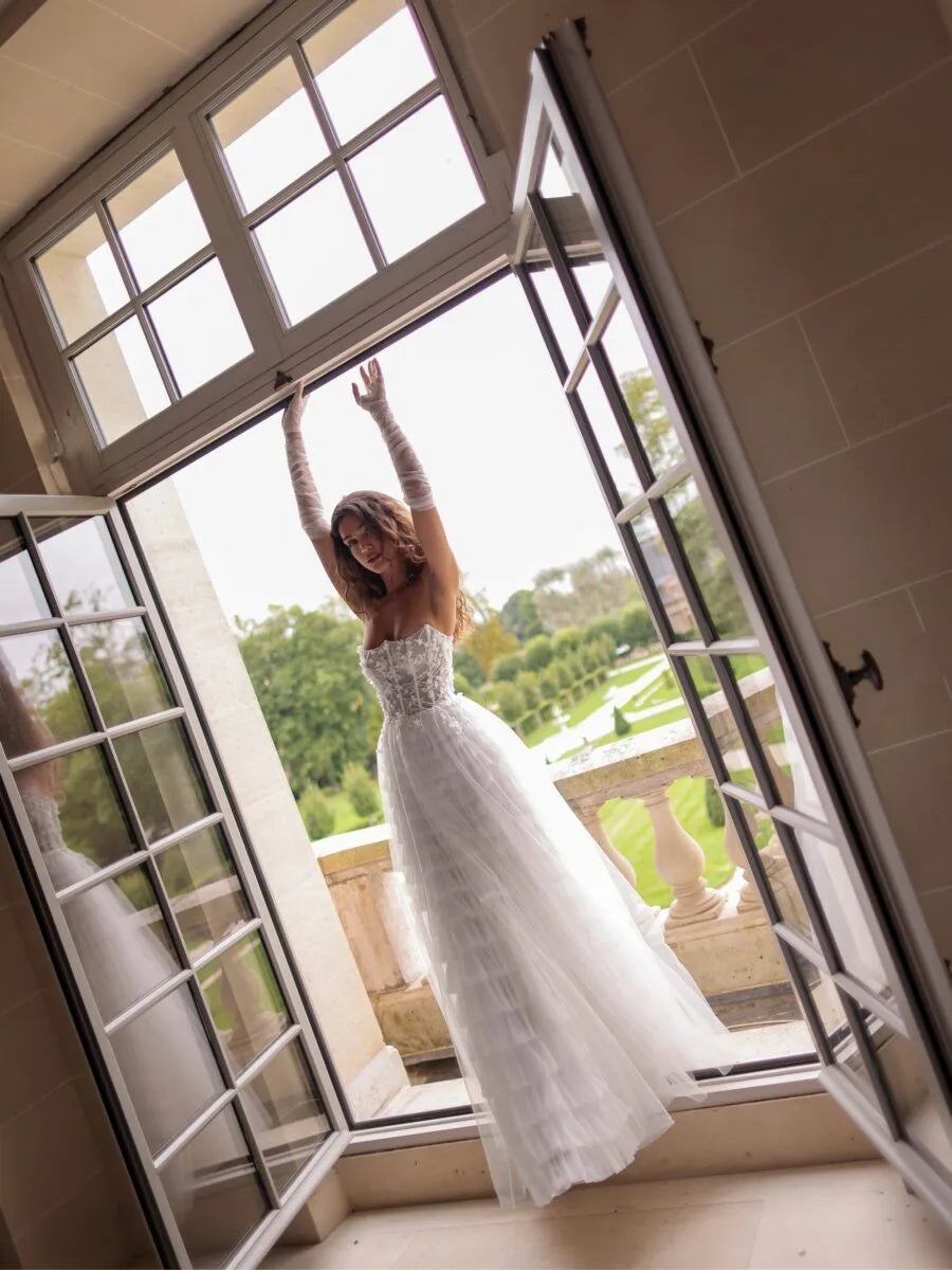 Boho bridal gown with floral appliqué top and tiered tulle skirt