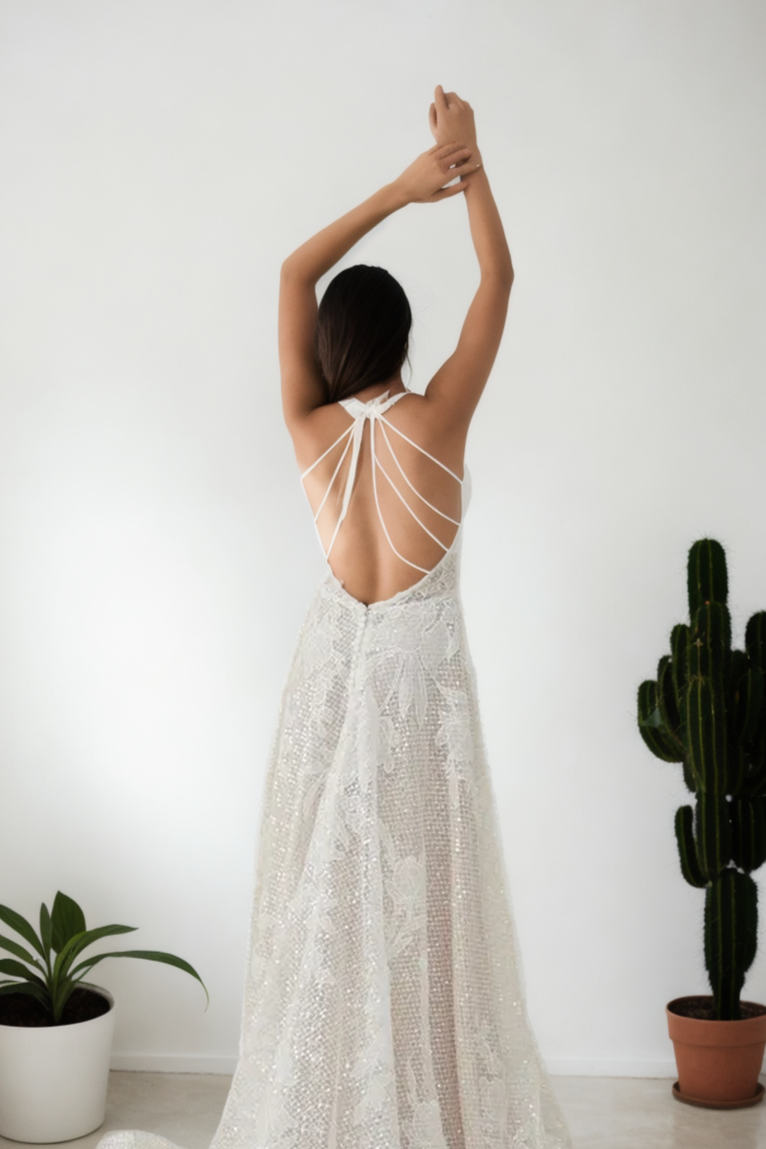 Custom Youthful A-Line Bridal Gown In Premium Off-White Beaded Lace With Halter Neckline, Sleeveless Design, Open Back, And Soft Flowing Train