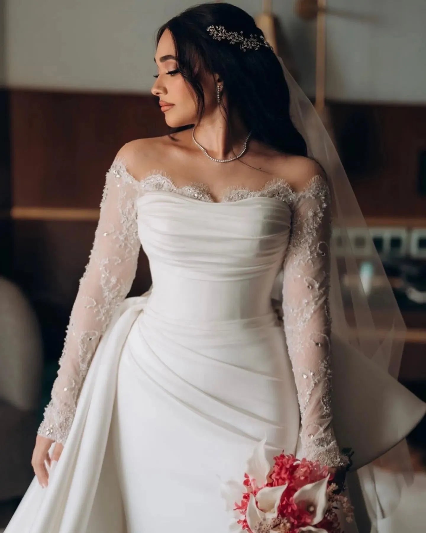 White mermaid bridal dress featuring beaded lace, off-shoulder bodice and custom fit silhouette.

