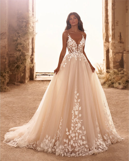 Bohemian A-line wedding gown with 3D floral applique cascading down soft tulle for a romantic bridal look