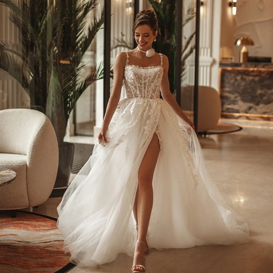 Romantic boho A-line wedding dress with floral lace applique and side slit, designed for elegant beach weddings.