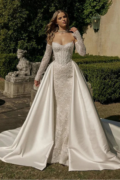 Elegant mermaid wedding dress with sweetheart neckline, lace long sleeves, and shimmering appliqué for brides seeking luxury couture.