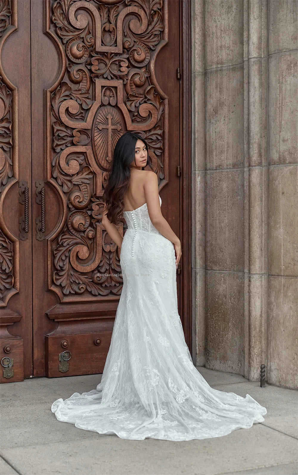 Fitted lace wedding dress with soft corset bodice, front slit and flowing mermaid lace train
