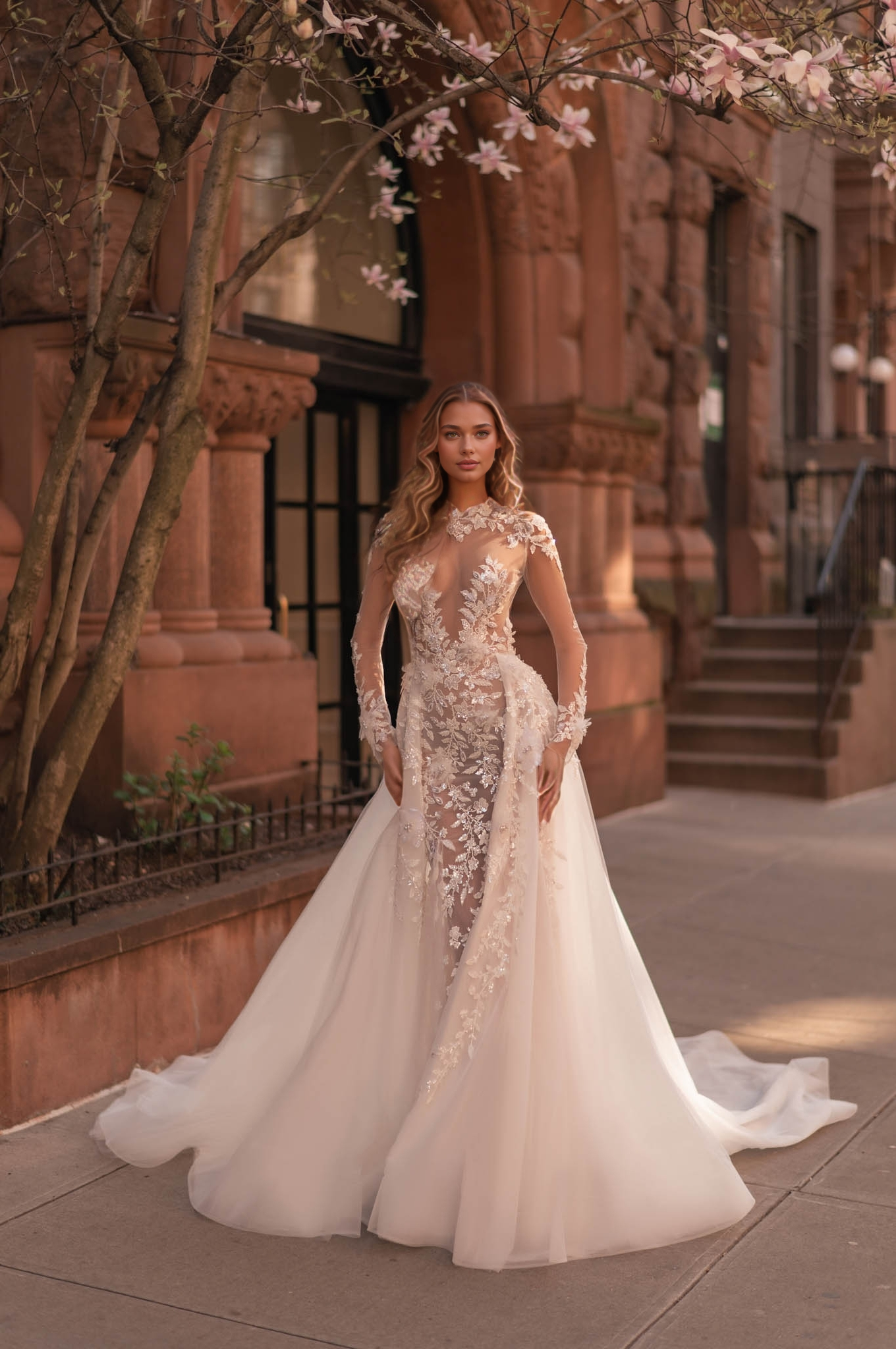 elegant long-sleeve lace wedding dress with sheer illusion and floral appliqués in an outdoor setting