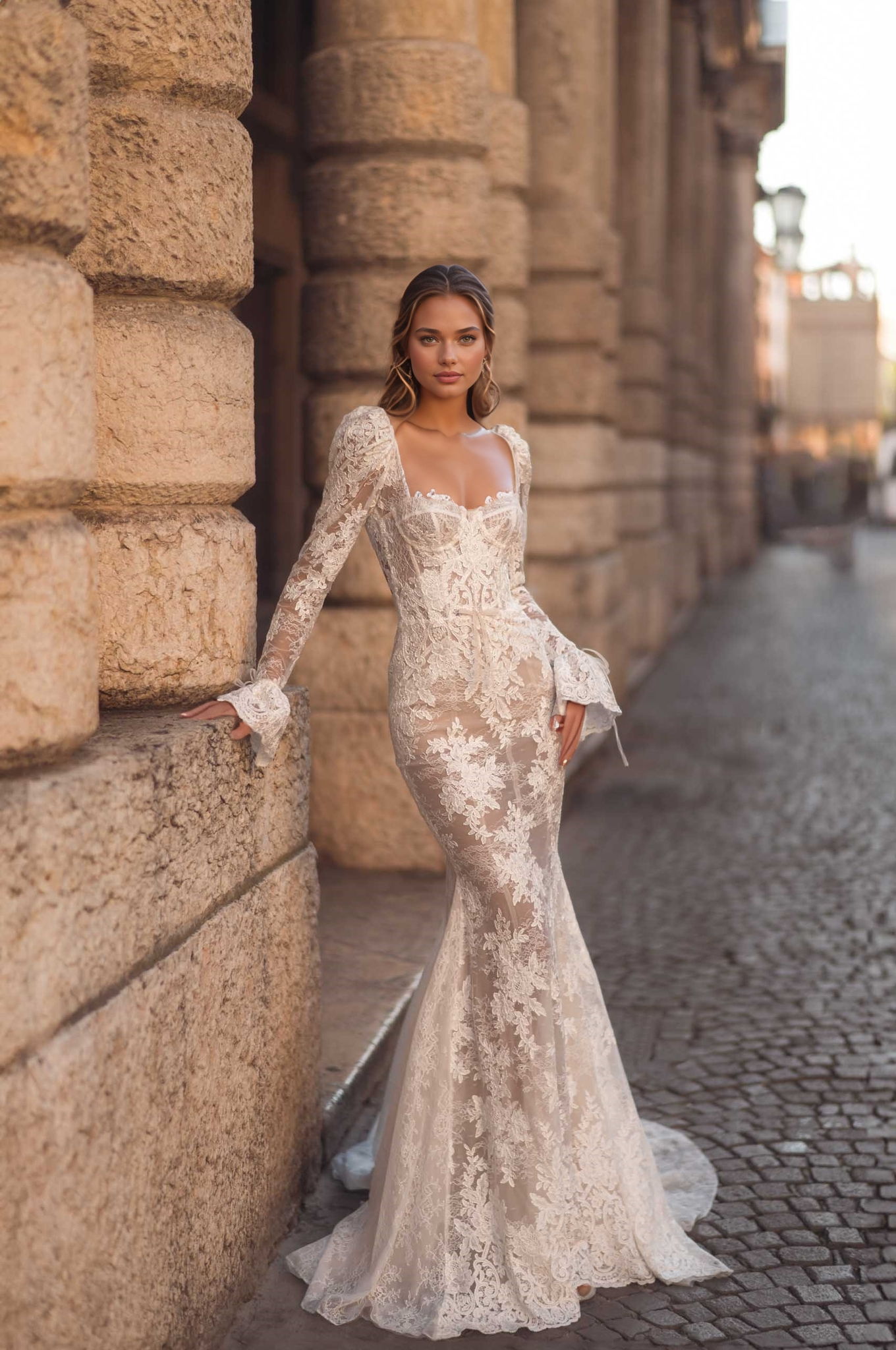 elegant long-sleeve lace wedding dress with square neck and sheer illusion on a classic cobblestone street