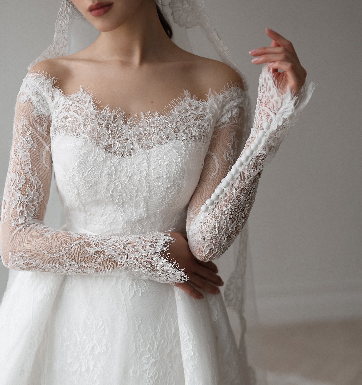 Elegant lace A-line bridal dress with full skirt and delicate sleeve details