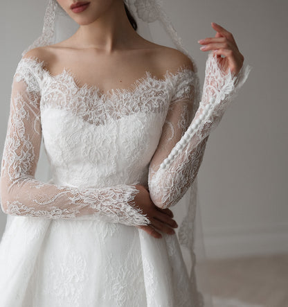 Elegant lace A-line bridal dress with full skirt and delicate sleeve details