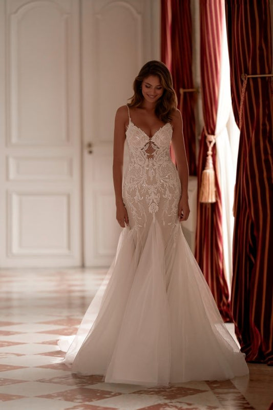 Mermaid wedding dress with lace appliqué and sheer illusion panel, featuring spaghetti straps and soft tulle train.