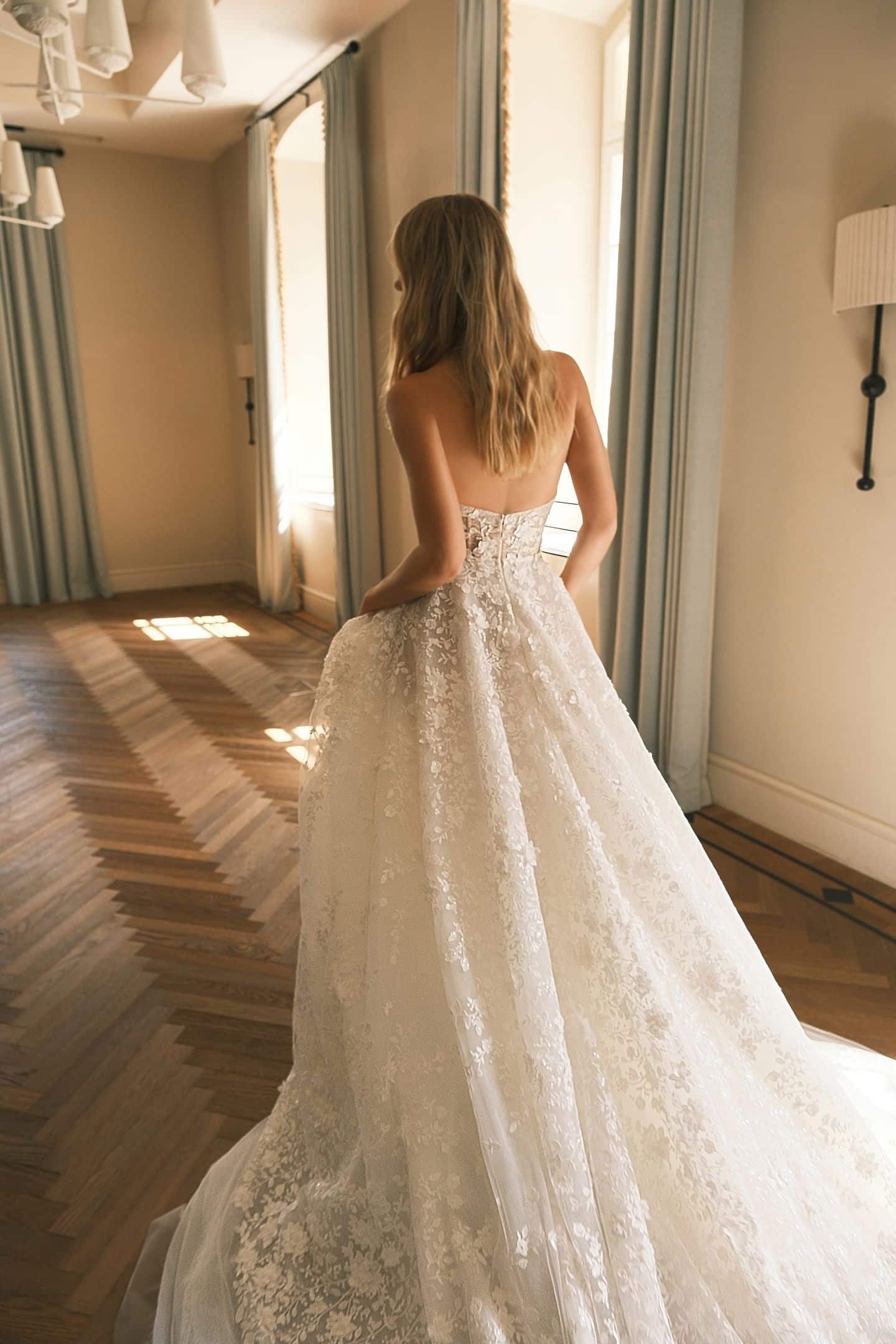 elegant 2025 off-shoulder lace wedding dress with sheer cape in a sophisticated indoor setting