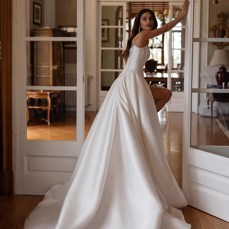 Minimalist bridal gown with pearl waistband and structured silhouette