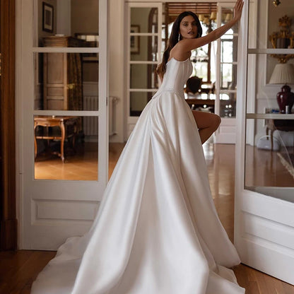 Minimalist bridal gown with pearl waistband and structured silhouette