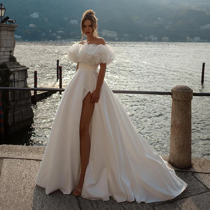 Off-shoulder ball gown wedding dress with 3D floral puff sleeves and high slit, perfect for romantic brides seeking elegance and uniqueness.