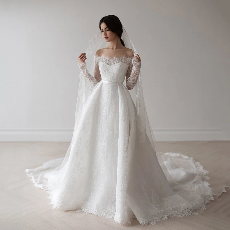 Romantic off-shoulder lace wedding gown with long sleeves and scalloped neckline