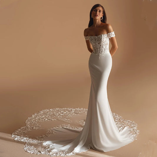 Elegant mermaid wedding dress with off-shoulder lace bodice, crepe skirt and floral sweep train for modern brides.