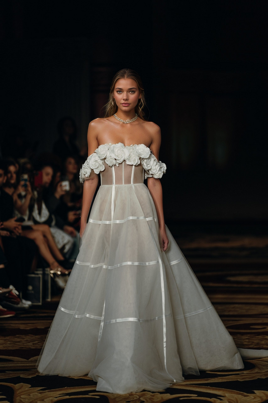 woman in off-shoulder sheer illusion wedding dress with floral accents and long train on a runway