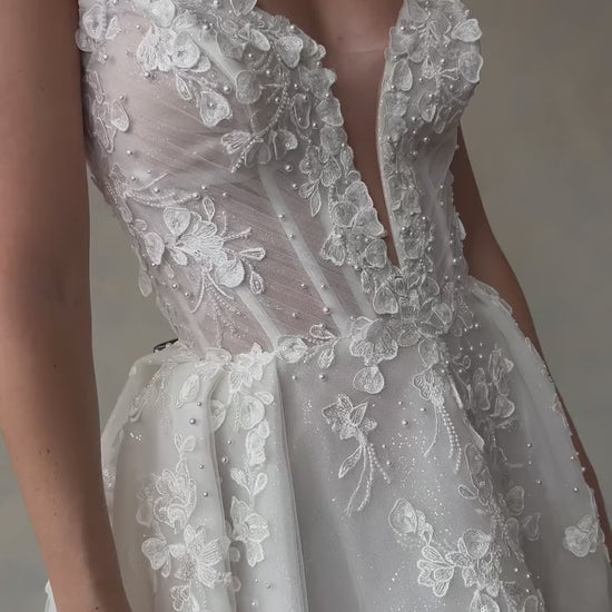 Romantic bridal gown with 3D floral lace and sparkly tulle layers, designed for elegance and fairy tale style.