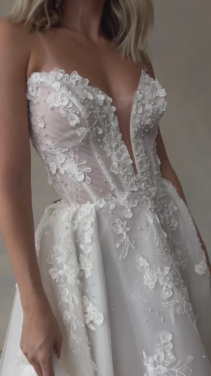 Romantic bridal gown with 3D floral lace and sparkly tulle layers, designed for elegance and fairy tale style.