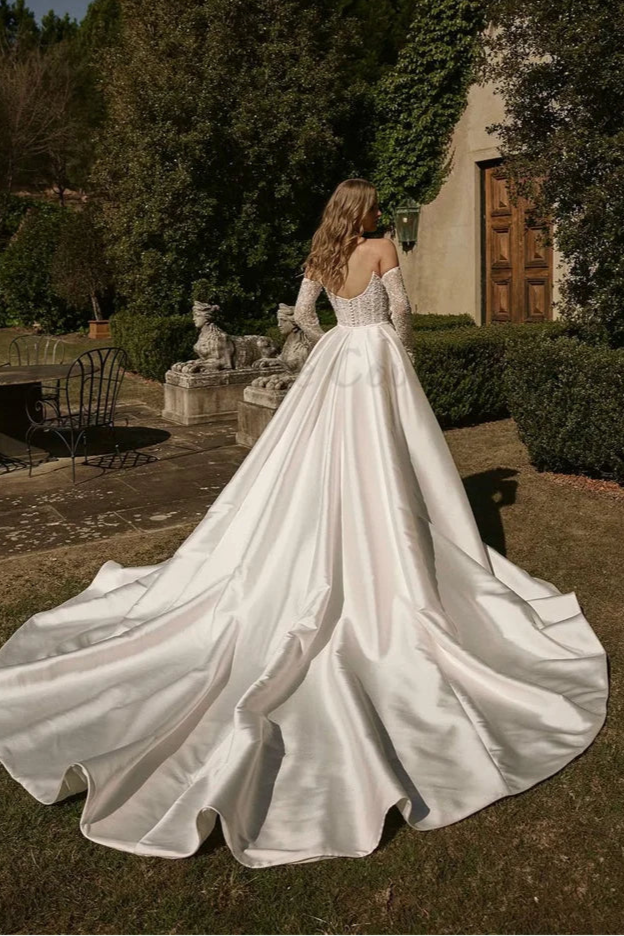 Modern wedding dress featuring fitted corset bodice and illusion lace sleeves, designed to flatter hourglass body types.
