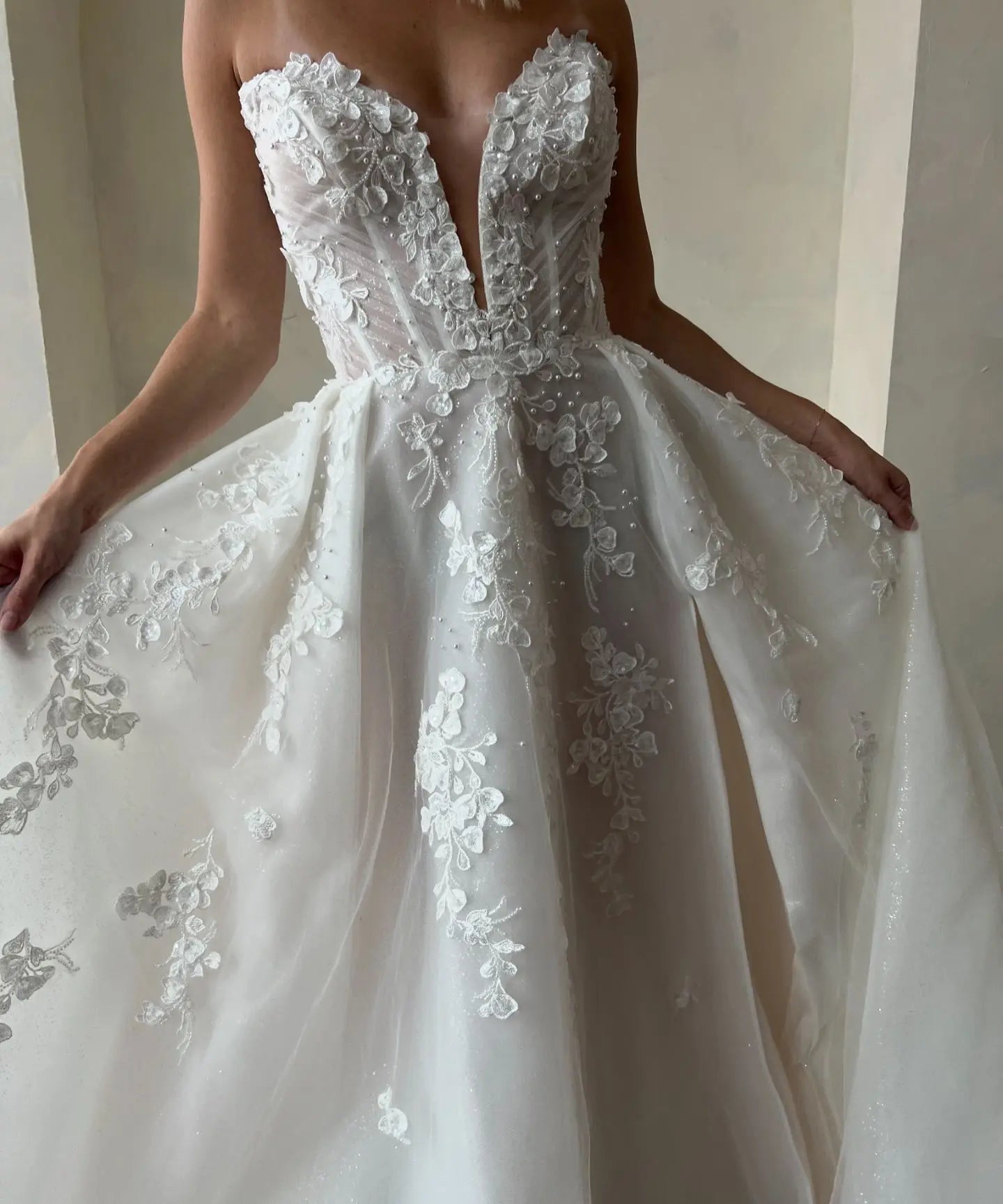 Romantic V-neck princess bridal gown with glitter tulle, floral details and a sculpted waist.
