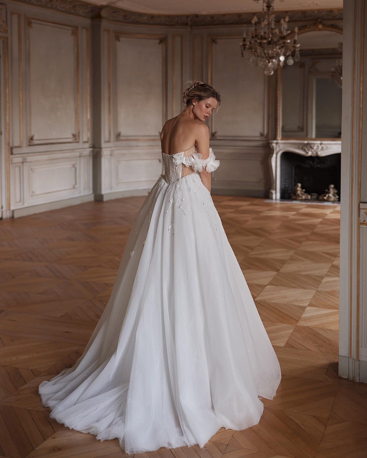 Back view of royal-inspired bridal gown with corset lace-up and flowing train