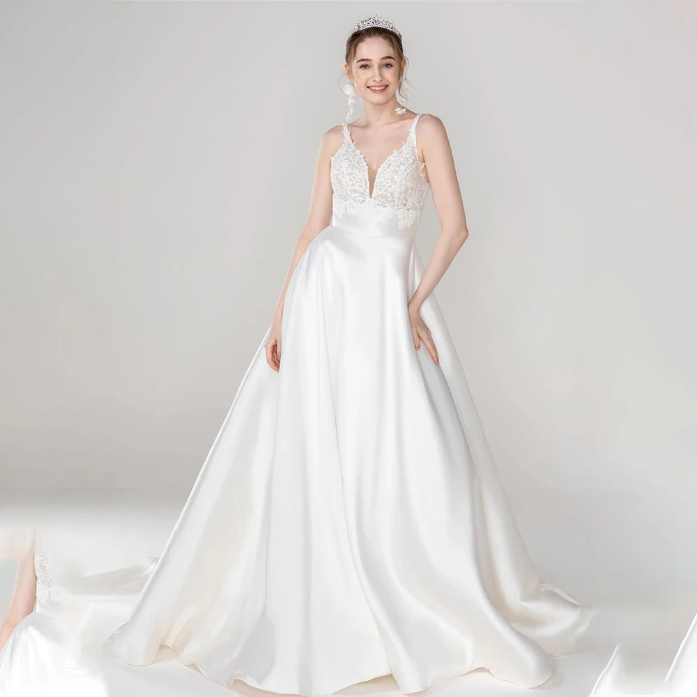 Luxurious satin A-line wedding dress with V-neckline, lace straps, and flowing skirt for timeless bridal elegance.