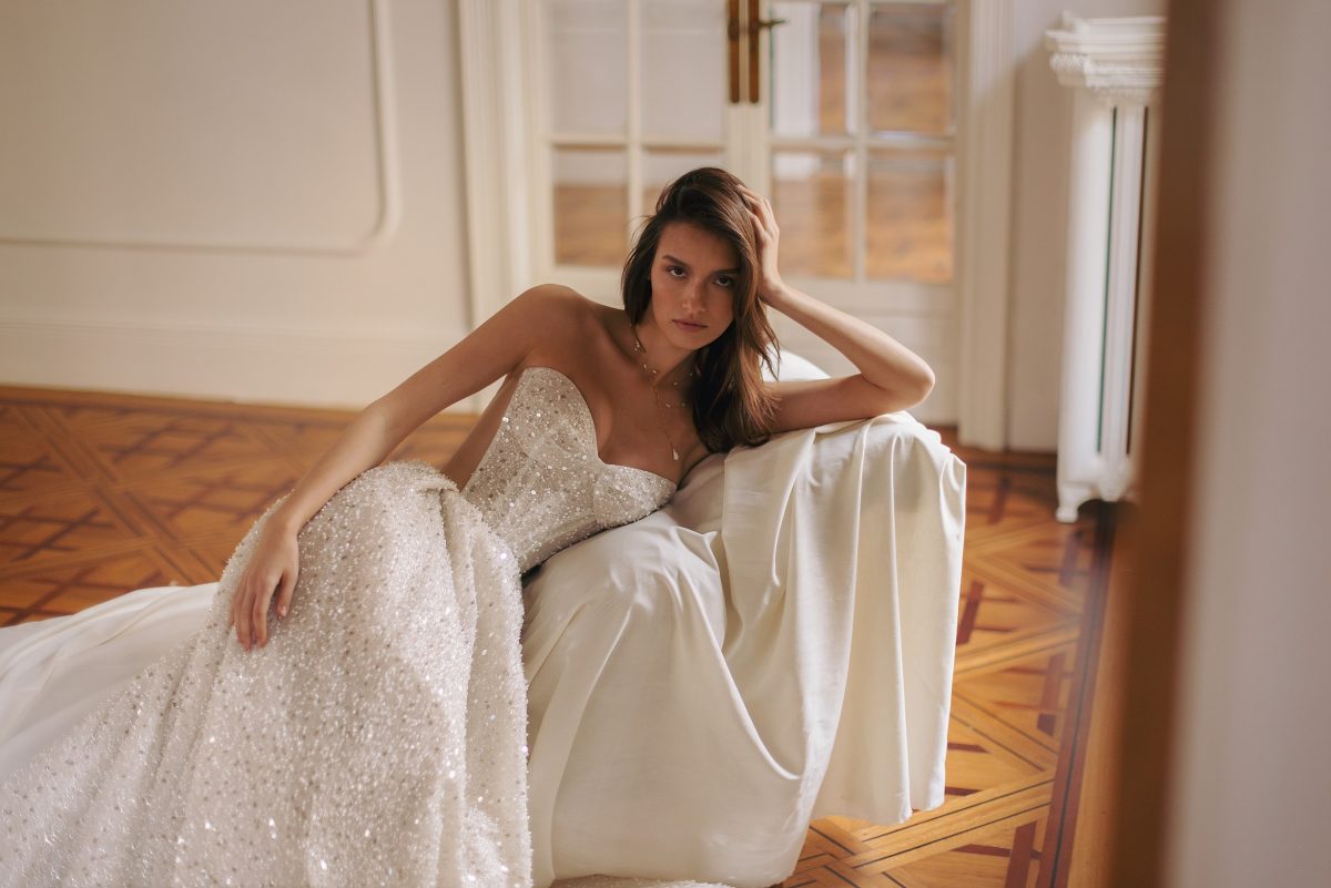 Sparkly wedding dress featuring strapless sweetheart style and flowing train