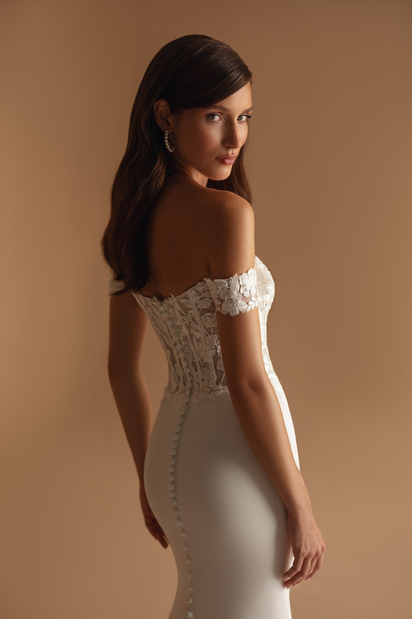 Full-length view of mermaid gown with soft crepe fabric and embroidered lace train detailing.
