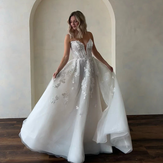  V-neck A-line wedding dress with floral lace appliqués, fitted waist, and full glitter tulle skirt for a romantic bride.