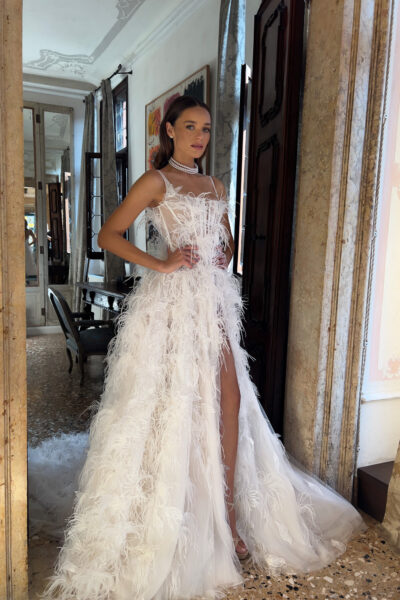 Feather embellished tulle wedding dress back view showcasing chapel train