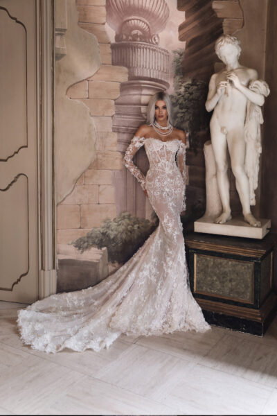 Bride posing side profile in lace mermaid gown with long train