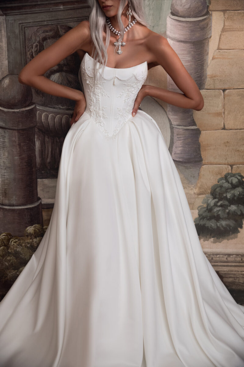 Full-length satin corset wedding gown with vintage backdrop